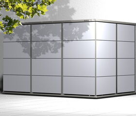 . Ein moderner grauer Gartenschrank mit Kacheldesign auf einer Terrasse, links ein Baumast mit Blättern.