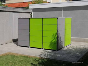. Ein modernes Gartenhaus mit grünen und grauen Paneelen auf einer gepflasterten Fläche.