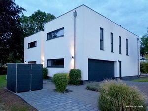 . Moderne, zweistöckige, weiße Villa mit großen Fenstern, Garage und gepflegtem Garten.