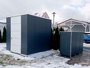 . Zwei moderne Gartenhäuschen in einem verschneiten Hof, mit Pflastersteinen und einem Auto im Hintergrund.