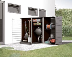 The image shows a storage shed with the doors open. Inside, there are various garden tools and items organized on shelves and hanging spaces:

1. Rakes and brooms on the left side.
2. Shelves with boxes and bags on the upper middle part.
3. A charcoal grill or similar item below the shelves.
4. Hoses coiled and stored on spools on the right.
5. A lawn mower at the bottom right.

The shed is adjacent to a building and surrounded by a grassy area.
