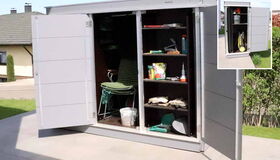 Ein geöffneter Gartenschrank mit Regalen, Gartenwerkzeug, Eimer, Stühlen und verschiedenen Gartenutensilien.