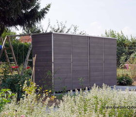 . Ein modernes Gartengerätehaus neben einer Schaukel in einem grünen Garten.