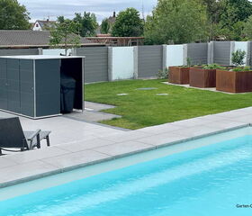 Ein moderner Hinterhof mit Pool, Gartenhaus, Stuhl und Hochbeeten auf grünem Rasen.