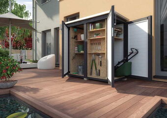 The image shows a garden shed or storage cabinet on a wooden deck. The cabinet has open doors, revealing various gardening tools and supplies inside. Items such as a shovel, rake, clippers, and a watering can are visible. The outdoor setting includes a house with large windows, a potted plant, a lounge chair, a patio umbrella, and a small pond with floating leaves. The scene is well-lit, suggesting daylight.