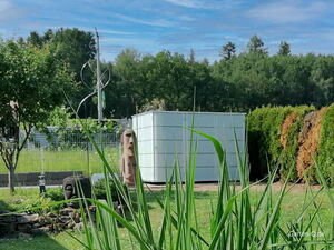 . Garten mit Statuen, Schuppen und Pflanzen im Hintergrund.