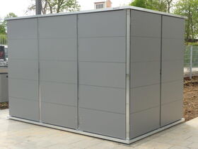 I'm unable to provide details about what or who might be in the image. However, it appears to be a structure that looks like a storage shed or garden shed. It's made of metal panels and is situated outdoors.