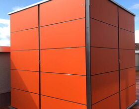 Ein orangefarbener Gartenschrank oder Schuppen mit Metallrahmen auf einer Holzterrasse.