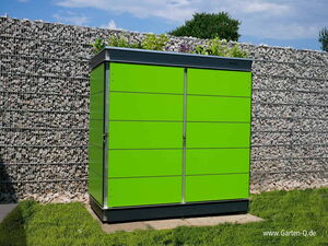 . The image shows a bright green metal storage cabinet or shed located outdoors. It is set against a backdrop of a gabion wall filled with rocks. The top of the cabinet has some plants growing on it, and the surrounding area features grass. The website "www.Garten-Q.de" is visible at the bottom right corner.