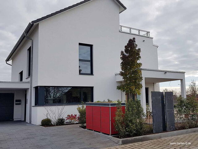 . Modernes zweistöckiges weißes Haus mit flachem Dach, großen Fenstern, Garten, rotem Schrank und Pflastersteinen.