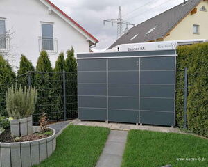 Ein ordentlicher Garten mit Rasen, Pflanzkübeln und einer modernen grauen Gartenbox vor Hecken.
