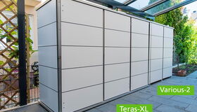 . Ein moderner, weißer Geräteschrank auf einer Terrasse mit grünem Pflanzenhintergrund.