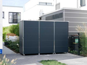 . The image features a modern, sleek outdoor storage unit with a minimalist design. It appears to be located in a residential setting, with surrounding elements like plants, a pathway, and nearby buildings. There's also a trash bin and fencing visible in the background, indicating it's part of an organized outdoor area.