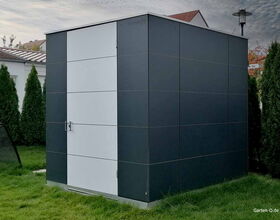 Ein moderner, dunkler Gartenschuppen aus Metall mit weißen Akzenten, umgeben von Rasen und Bäumen.