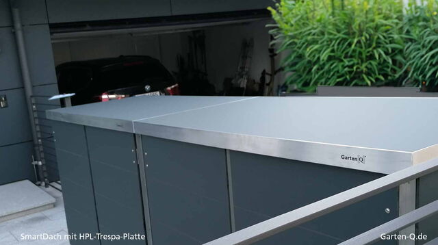 HPL-Trespa-Platte als SmartDach über Garten-Q-Abfallbox neben Garage und Pflanzen.