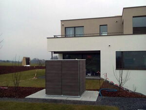 . Modernes zweistöckiges Haus mit großem Garten, Rasen und kubischem Außengebäude.