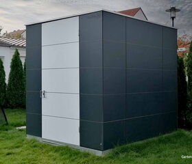 . Ein modernes Gartenhaus mit grauen Paneelen und weißer Tür, umgeben von Rasen und Bäumen.