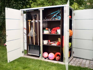 . This image shows an open outdoor storage cabinet or shed with various garden and recreational items. Here's an array of what can be seen:

1. **Left Section:**
   - Rake
   - Shovel
   - Snow shovel
   - Net

2. **Middle Section:**
   - Pruning shears
   - Paint can
   - Spray bottle
   - Small gardening tools
   - Red cloth or bag

3. **Bottom Section:**
   - Several balls (e.g., basketball, soccer ball)
   - Bucket and miscellaneous equipment

These items are stored neatly inside the cabinet, which is situated outdoors in a garden or yard setting.