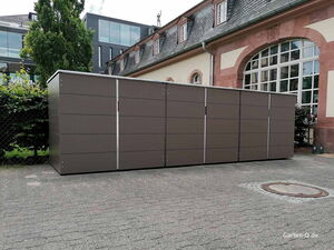 . Ein großer, moderner Abstellschrank im Freien neben einem Gebäude.
