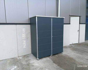 Ein grauer Geräteschrank mit 188 cm Höhe steht an einer Hauswand.