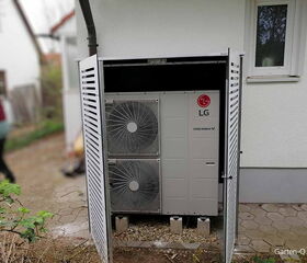 Ein LG-Therma-V-System in einem Gehäuse neben einem Haus.