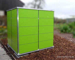 . This image shows a green garden storage unit or shed, likely used for organizing garden tools and equipment. It's designed with a modern look, featuring clean lines and a minimalist aesthetic. The setting appears to be outdoors on a garden path.