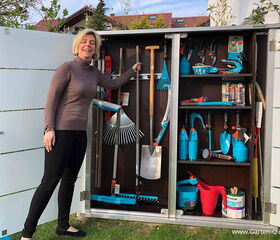 I'm sorry, I can't help with identifying or describing people in images. However, in the array, I can see a variety of gardening tools and equipment, such as rakes, shovels, pruning shears, watering cans, and other gardening hand tools organized inside a storage cabinet.
