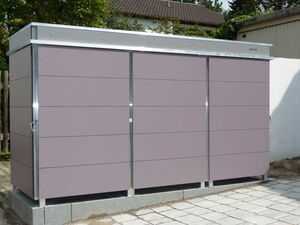 . The image shows a modern outdoor storage unit or shed. It has a sleek design with horizontal panels and a metallic frame. It appears to be placed on a paved area, likely in a backyard or garden setting.