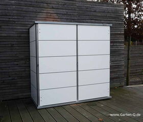 . Ein weißer Gartenschrank vor einer Holzpaneelwand im Freien.