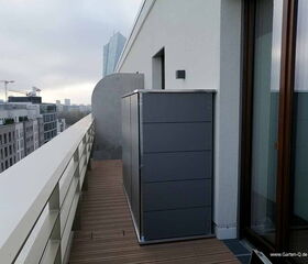 Ein Balkon mit modernem Schrank, Holzboden, Blick auf Stadtgebäude und Wolkenkratzer im Hintergrund.