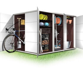 . The image depicts a shed or storage unit with open doors, displaying various items inside. Here's a detailed list in array format:

- Bicycle
- Shovel
- Bags labeled "Holzkohle" (charcoal)
- Sports equipment (balls)
- Outdoor tools (rakes, hoes)
- Watering can
- Flower pots
- Garden hose
- Garden tools (broom, spade)
- Various storage containers and boxes

These items are organized on shelves within the unit.
