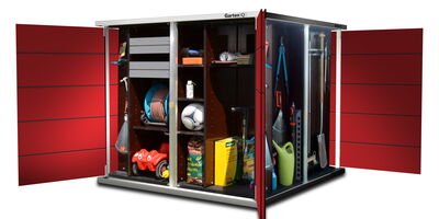 The image shows an open garden storage cabinet with various items inside. Here’s what can be seen:

- Shelves with small drawers.
- A hose reel.
- A soccer ball.
- Children's toys, such as a small ride-on car.
- A rake.
- A watering can.
- Garden tools like a shovel.
- Various gardening supplies and boxes.

The cabinet seems organized for storing gardening tools and outdoor equipment.