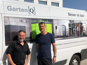 . Zwei Männer posieren vor einem Lieferwagen mit GartenQ-Werbung für Gartenschränke und Unterstände.