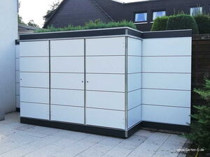 . Ein moderner, weißer Gartenschrank mit schlichten Linien, auf einer Terrasse, umgeben von Pflanzen.