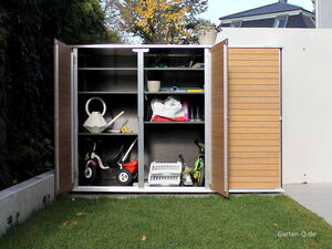 . Ein offener Gartenschrank mit Gießkanne, Spielzeug, Pflanzentöpfen und Gartengeräten auf Rasen.