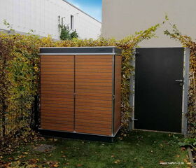 . Ein orange-brauner Gartenschrank steht neben einer dunklen Tür, umgeben von Laubhecken und einem Gebäude im Hintergrund.