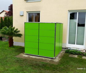Grünes Gartenschrank neben Hauswand, Palme im Garten, Rasen und Fenster.