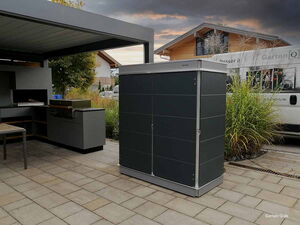. Moderne Außenküche mit Grill und dunklem Gartenkabinett auf einer Terrasse bei Abenddämmerung.